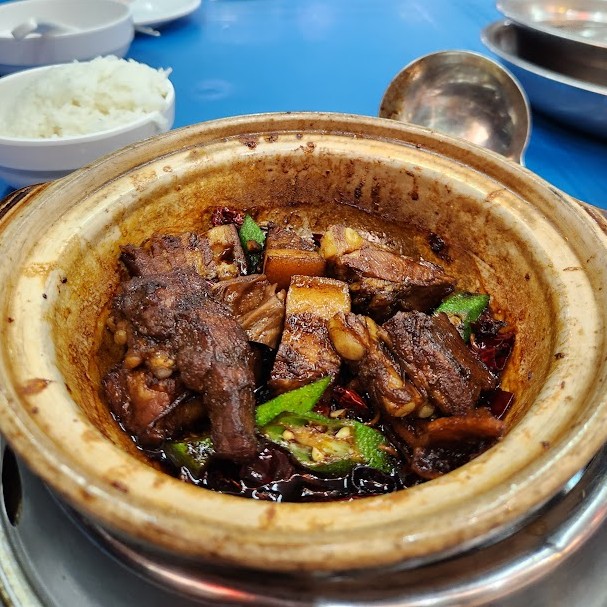 黒いタレで煮込まれたドライバクテーとオクラが入った土鍋料理